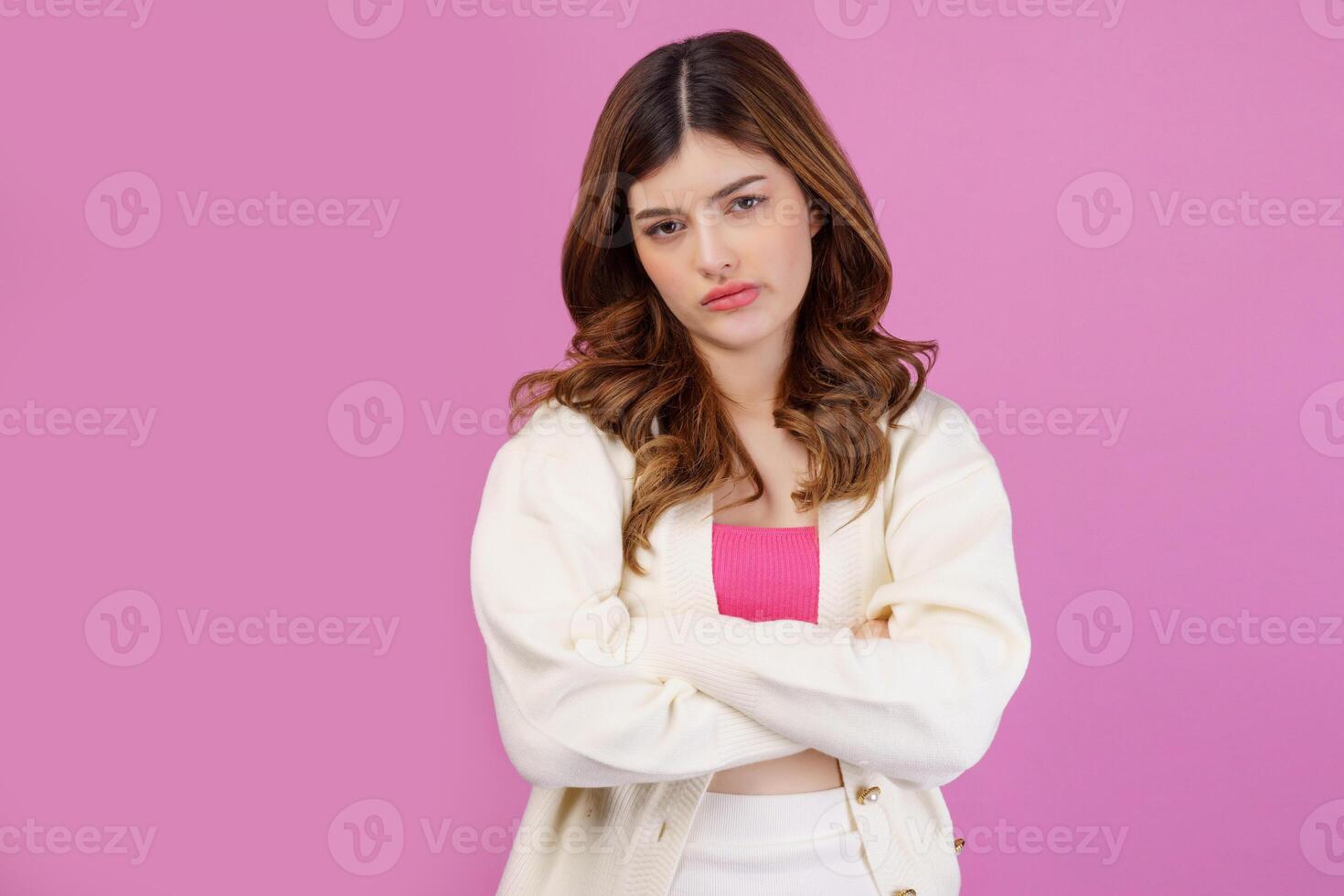 Portrait of depressed sad young woman cross arm isolated over pink background photo