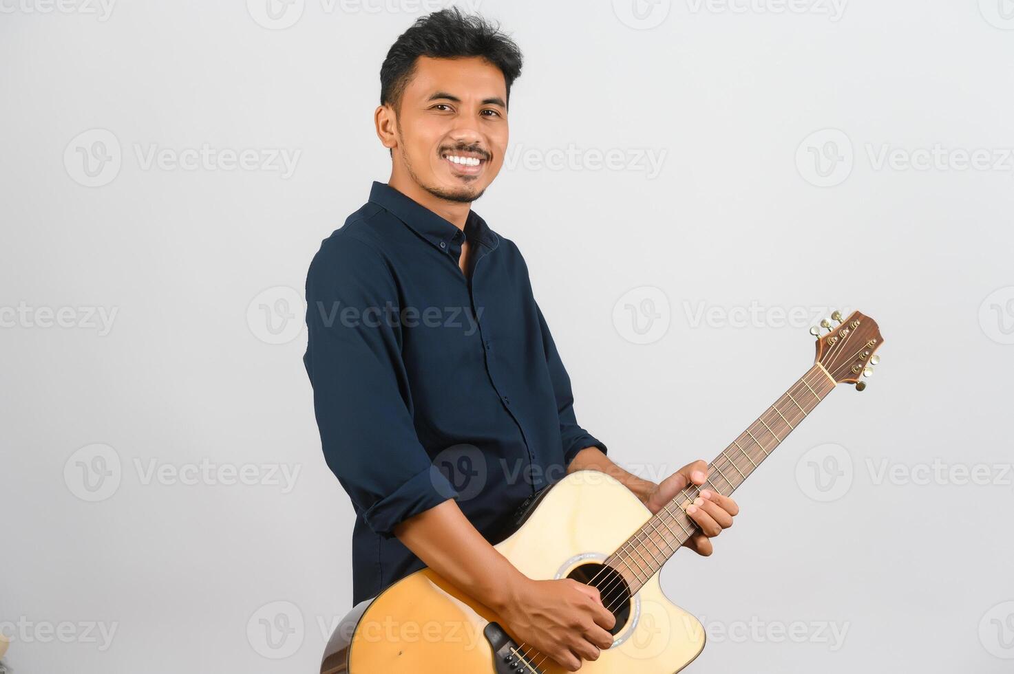 Portrait of Young Asian man playing an acoustic guitar isolated on white background photo