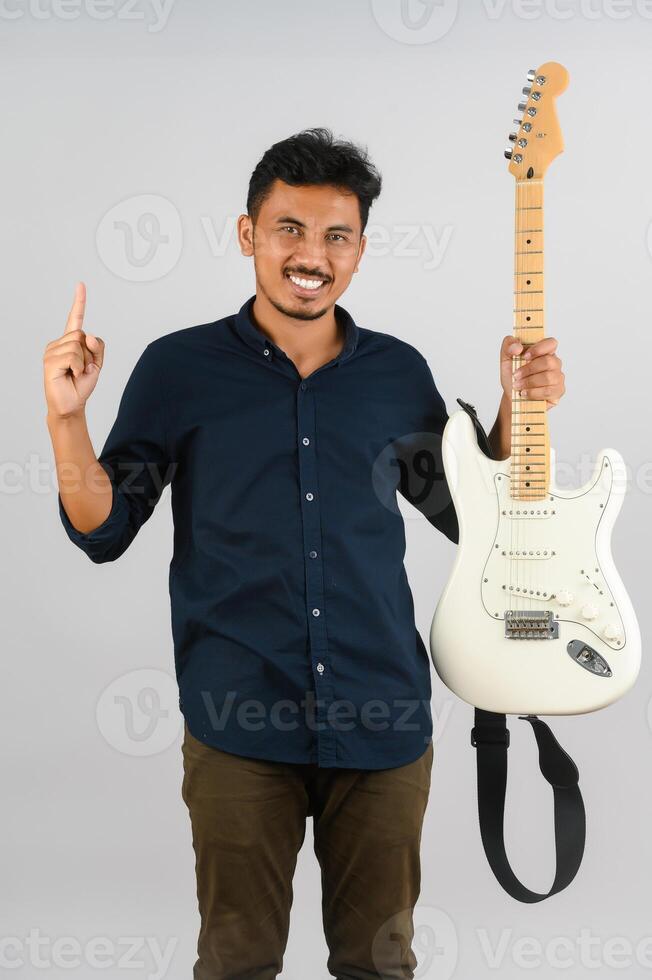 Portrait of Young Asian man in blue shirt with electronic guitar isolated on white background photo