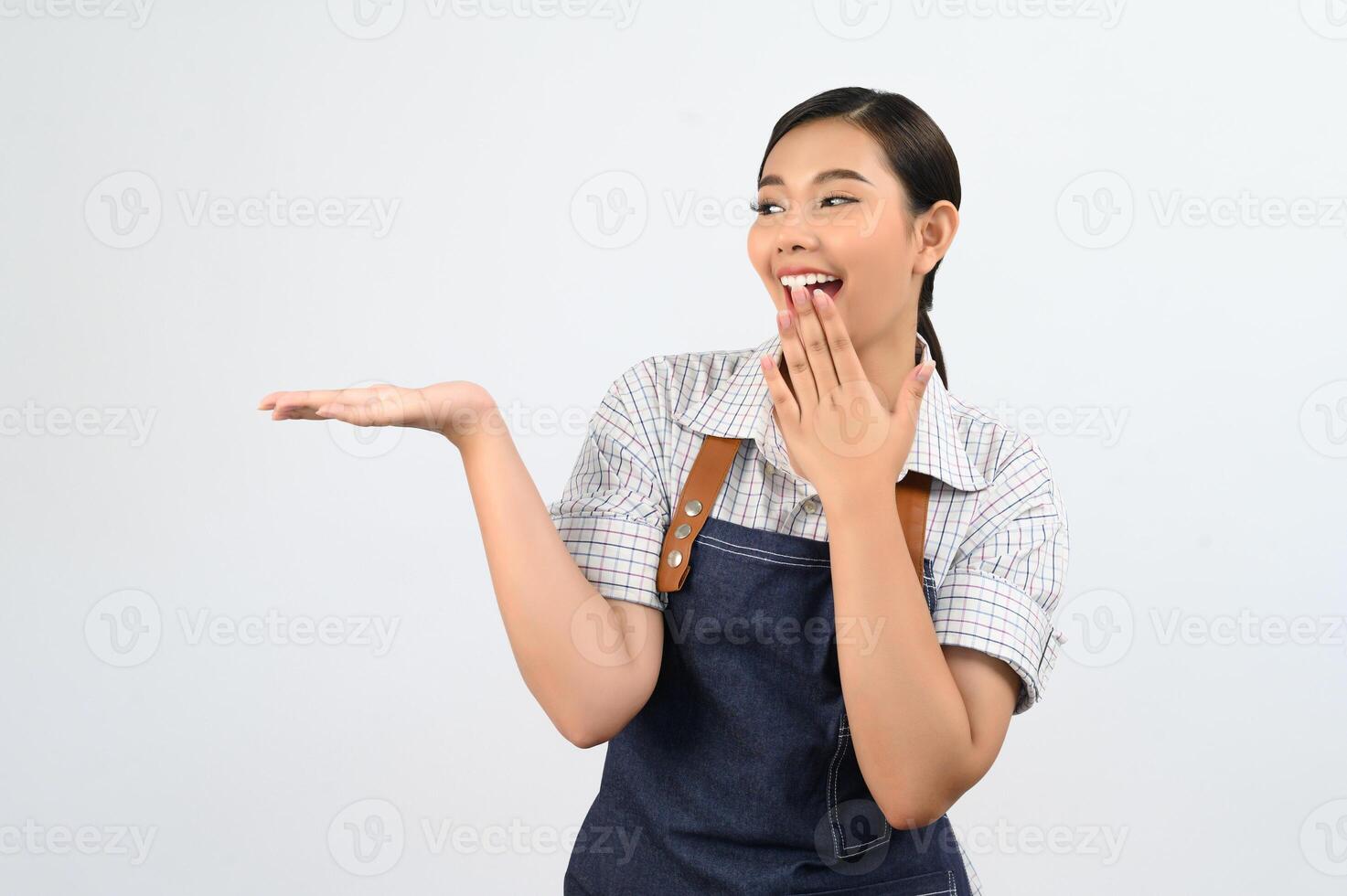 Retrato de mujer joven asiática en uniforme de camarera con postura de palma abierta foto
