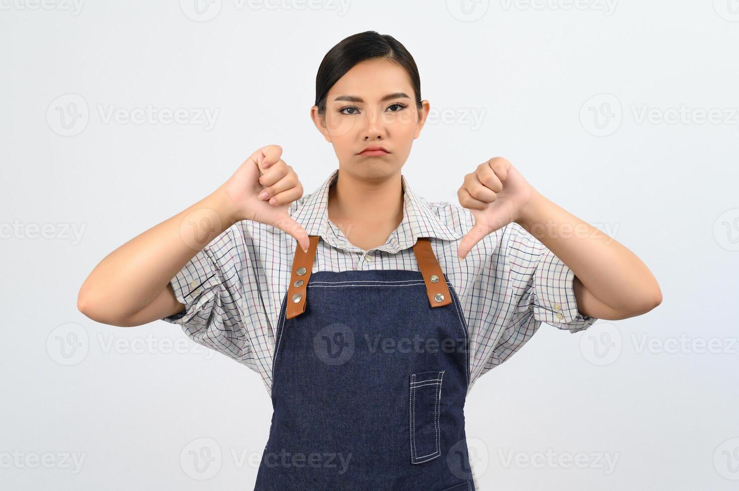 Portrait Asian young woman in waitress uniform with upset posture photo