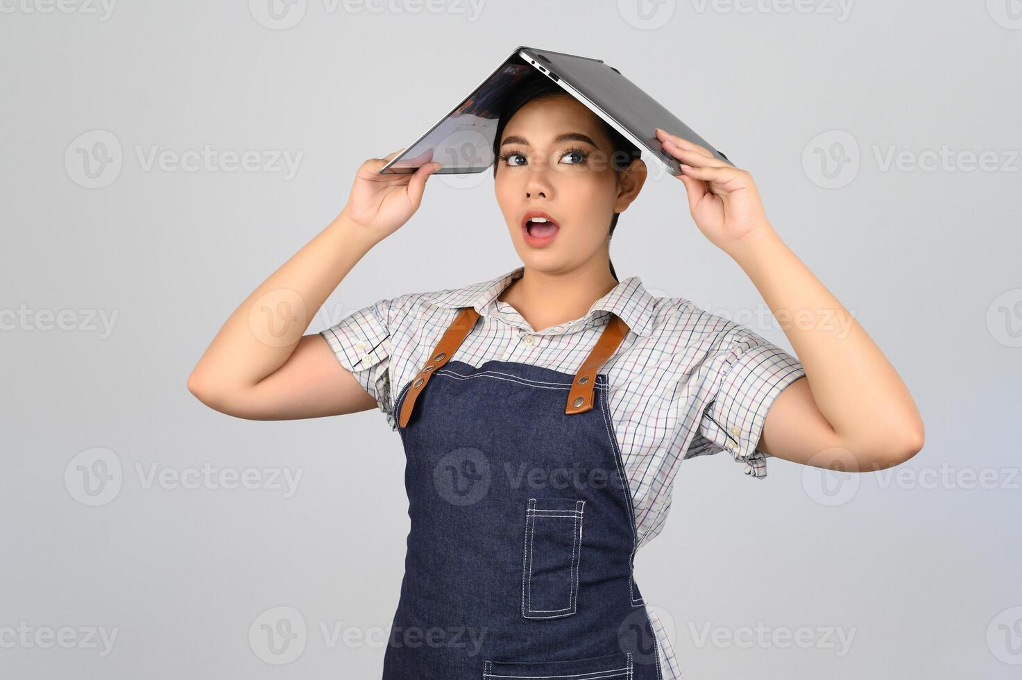 Portrait of young asian woman in waitress uniform pose with laptop computer photo