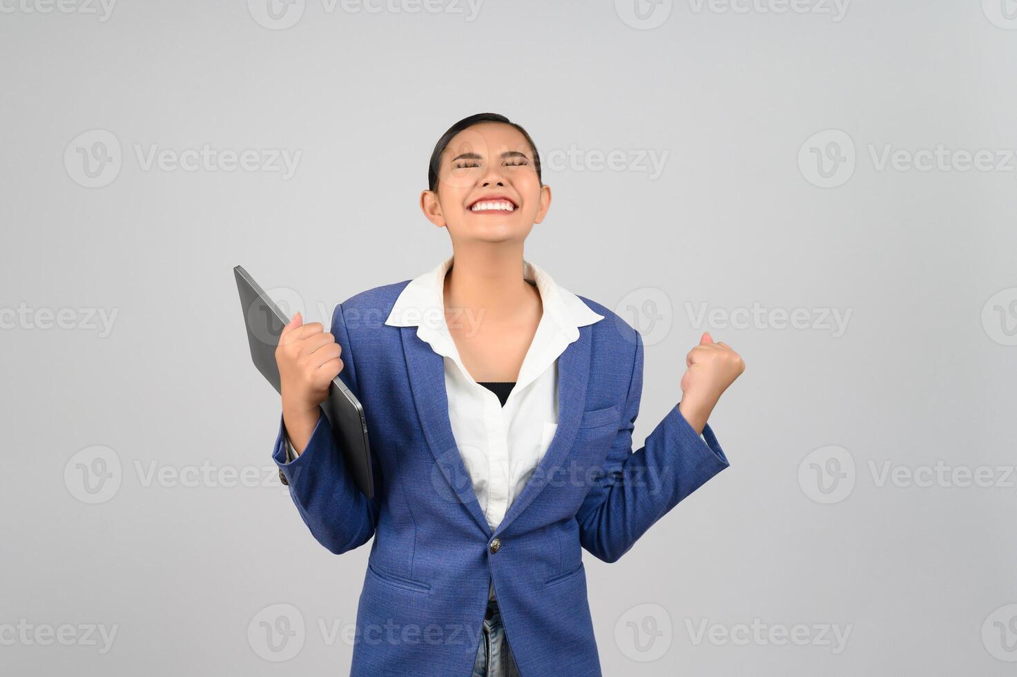 Young beautiful woman in formal clothing for officer holding laptop computer photo