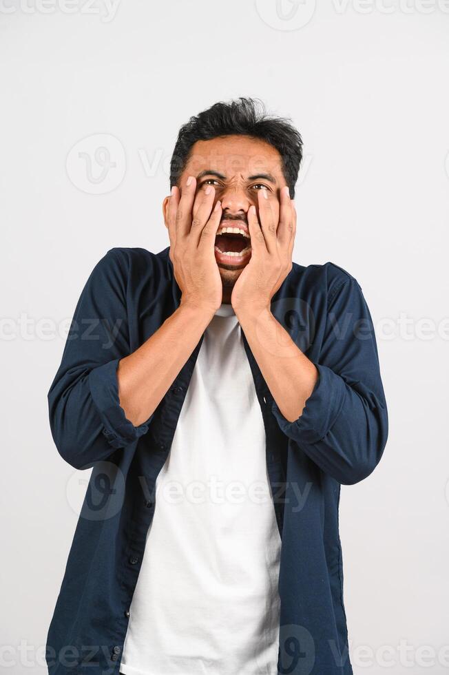 retrato de un joven asiático decepcionado con camisa azul molesto enojado con un gesto furioso aislado de fondo blanco foto