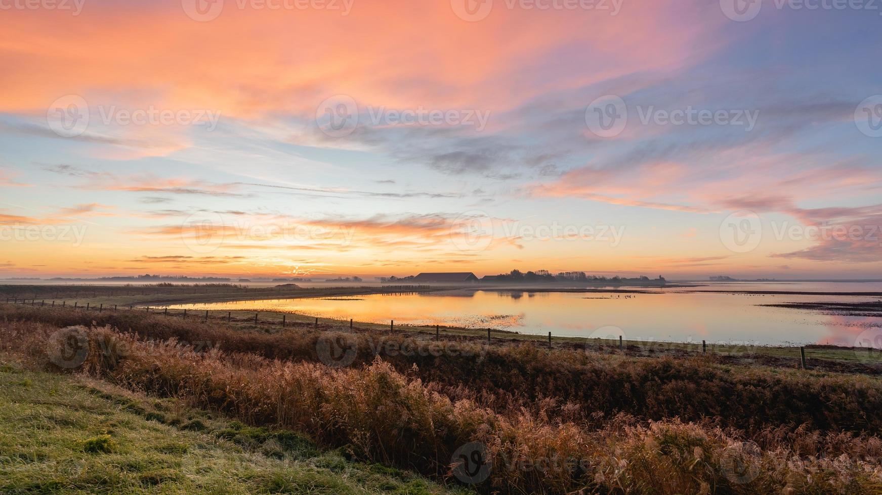 hermoso amanecer sobre el campo holandés. den osse, zelanda, los países bajos. foto