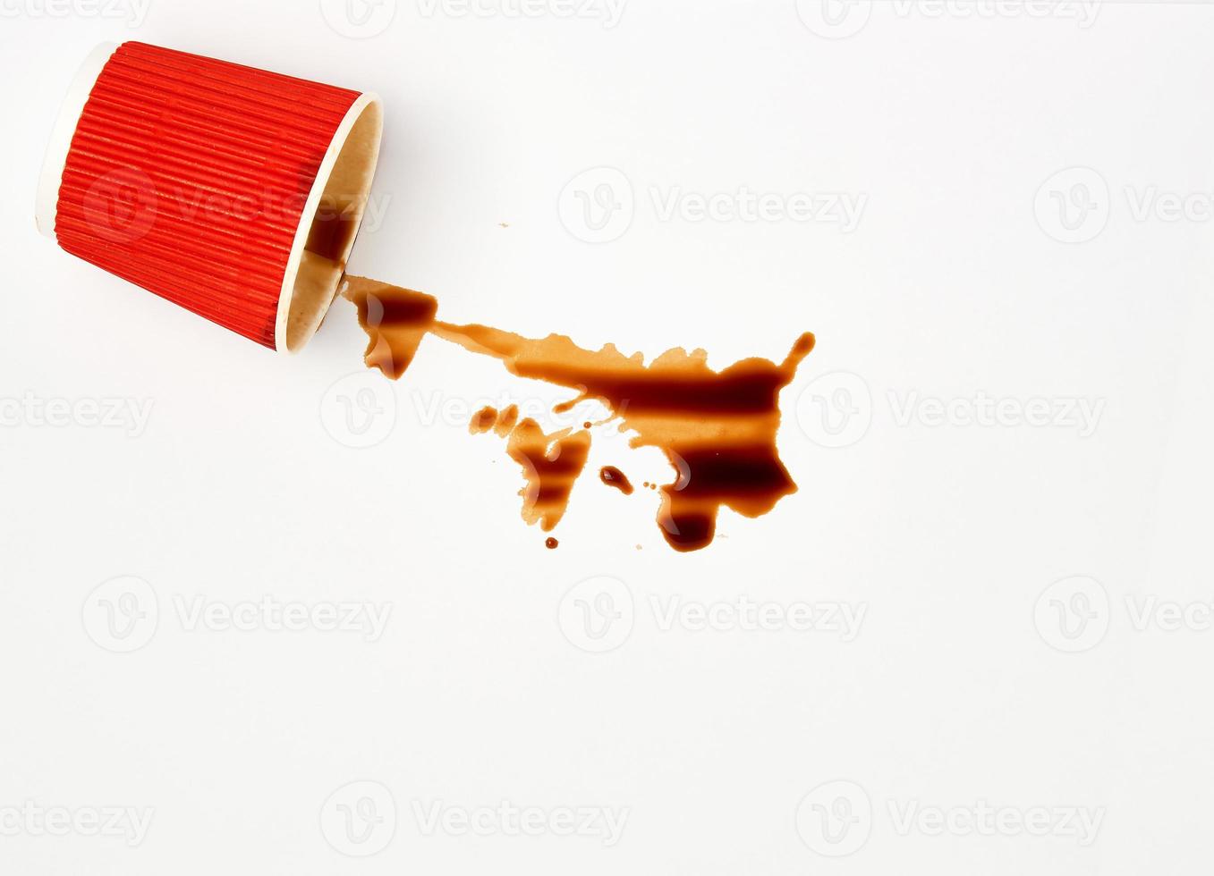 spilled black coffee from a red paper cup on a white background photo