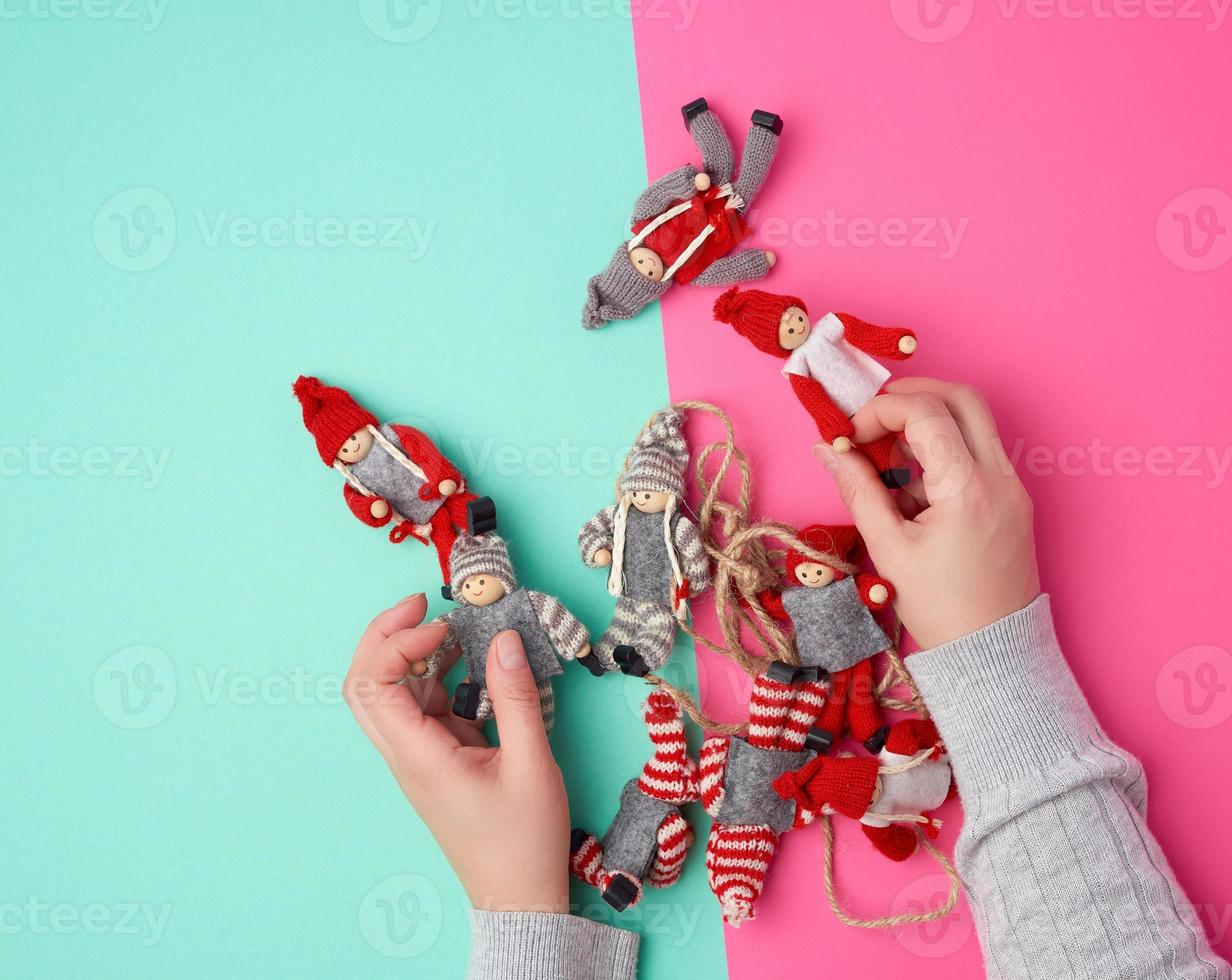 dos manos femeninas y juguetes navideños en un fondo coloreado foto