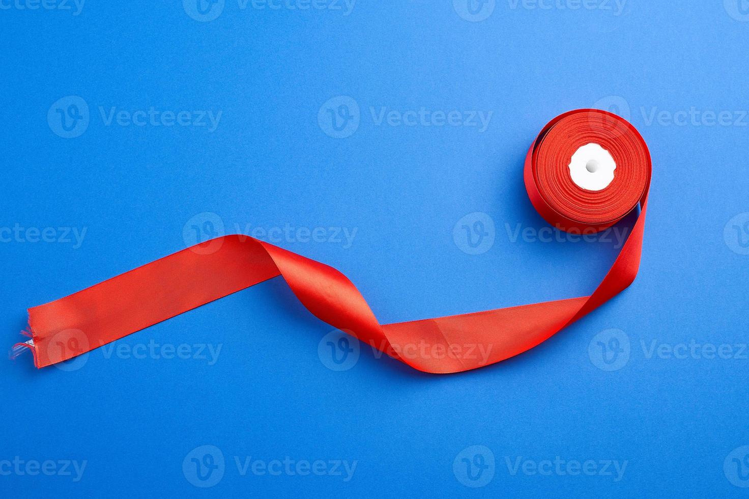 spools with red satin ribbon on a blue background photo