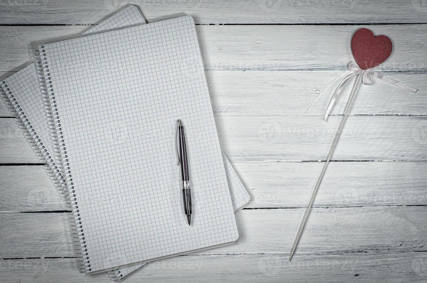 Open notebook in the small cell with a pen photo