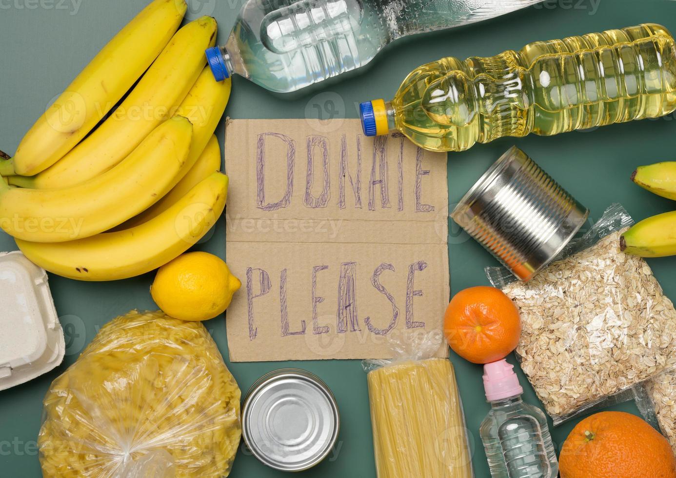 inscription on the cardboard please donate various products. Fresh fruits, pasta and canned food photo