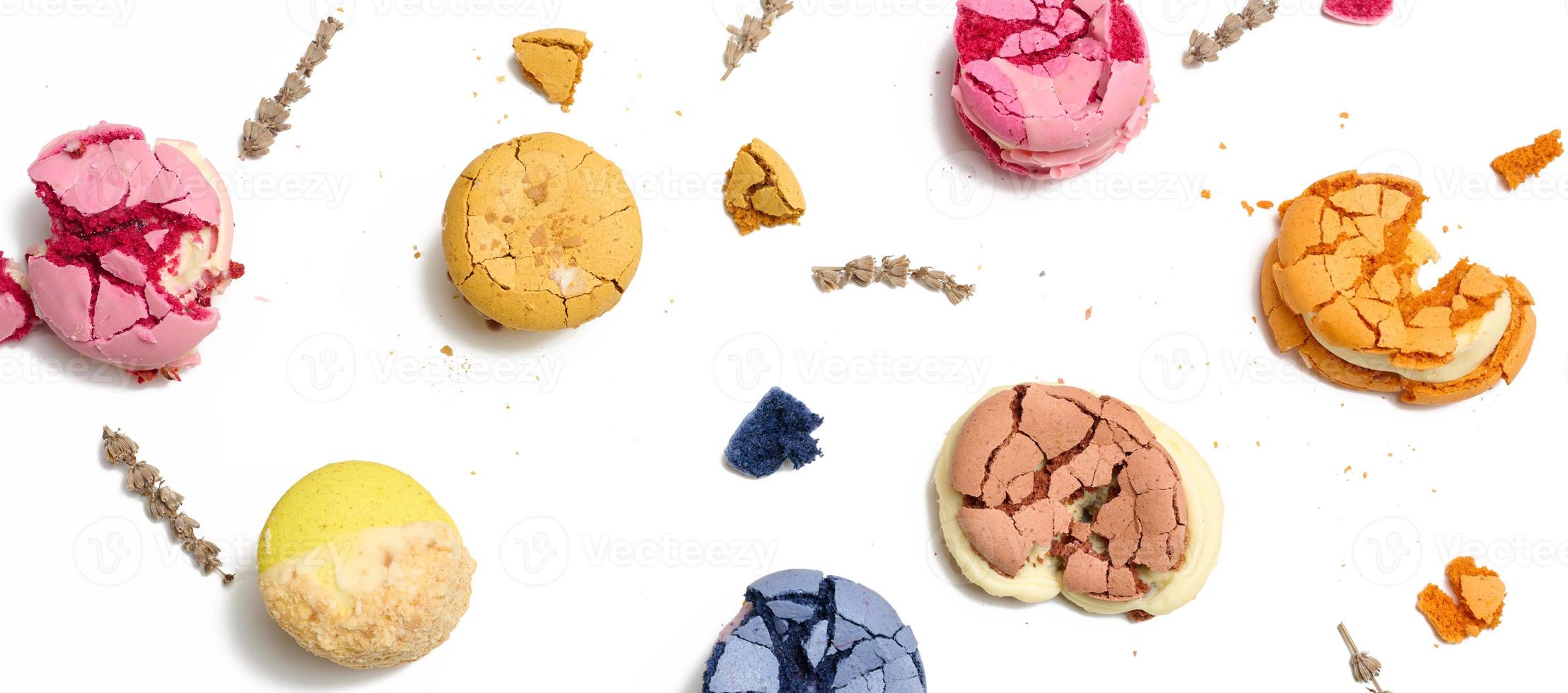 Broken round macarons with crumbs on a white background, delicious dessert photo