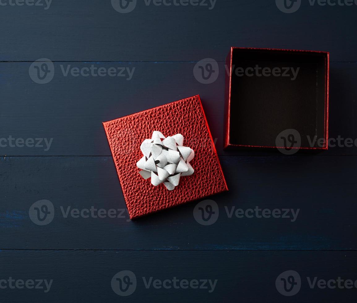 open empty red square cardboard box on a blue wooden background photo