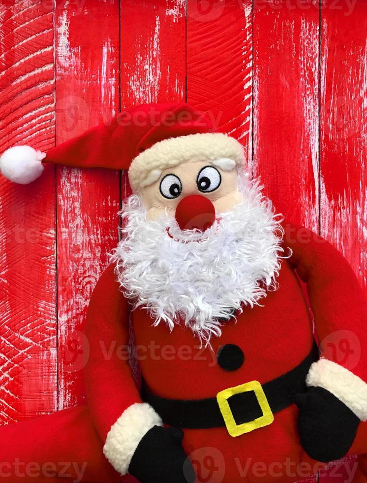 Papá Noel feliz sobre un fondo de madera roja foto