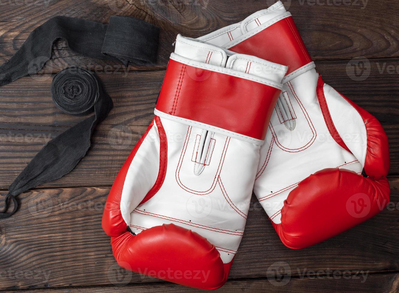 pair of red leather boxing gloves and elastic black bandage photo