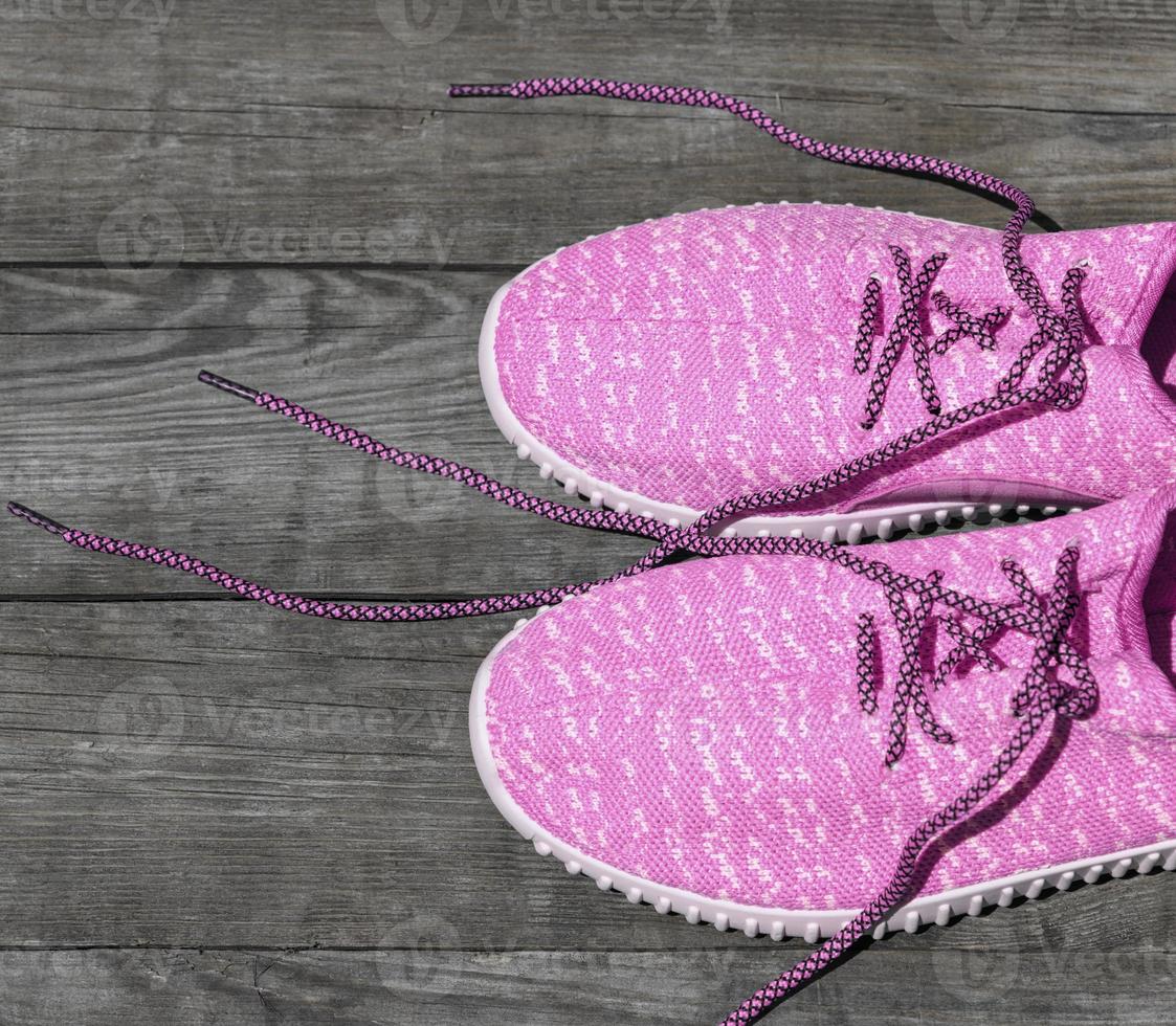 pink textile shoes with untied laces photo