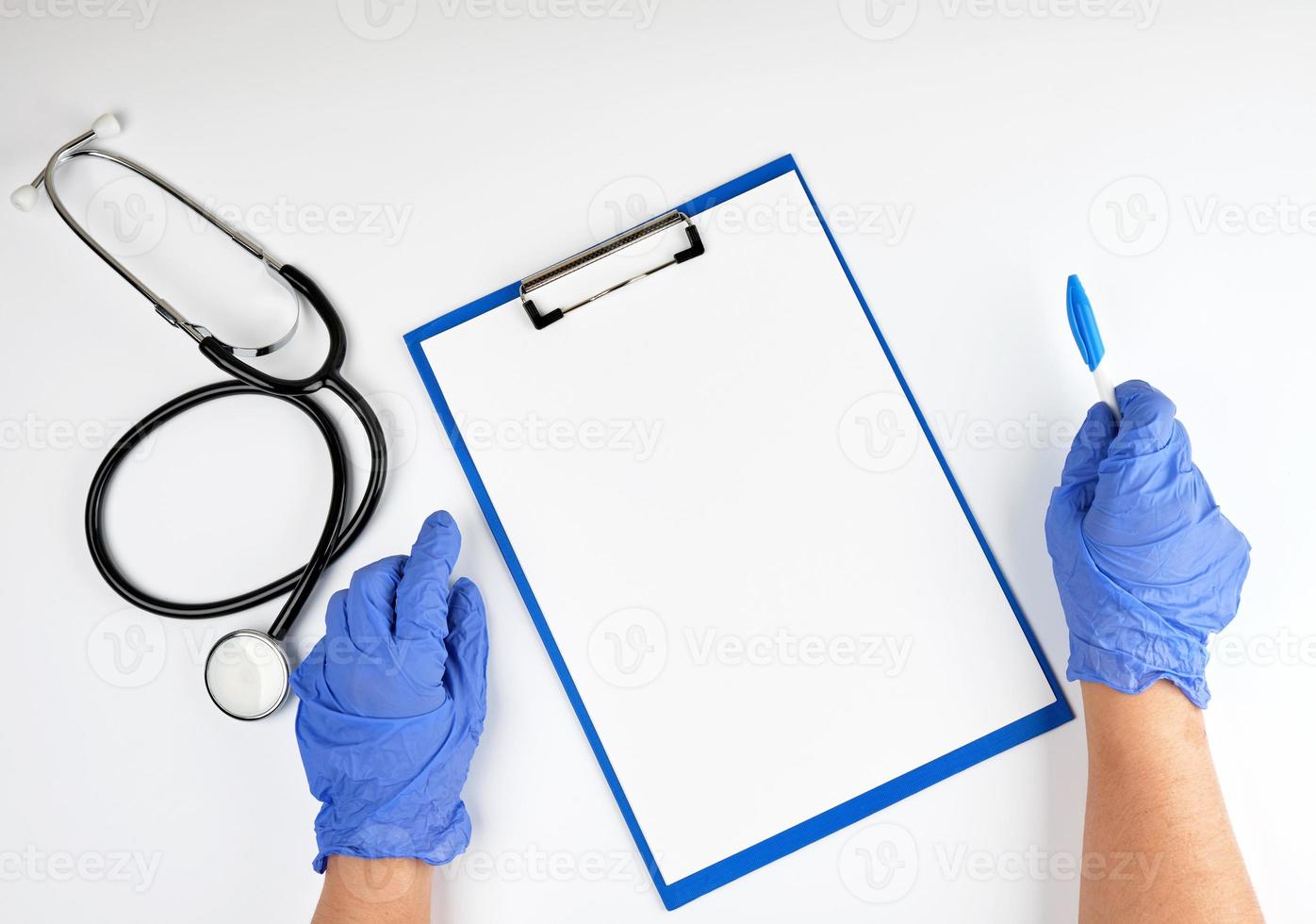 mano en guantes estériles azules y estetoscopio médico foto