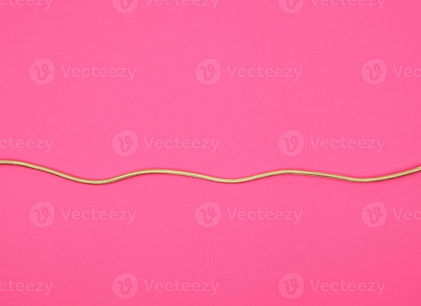 golden cable for equipment in textile winding on a pink background photo