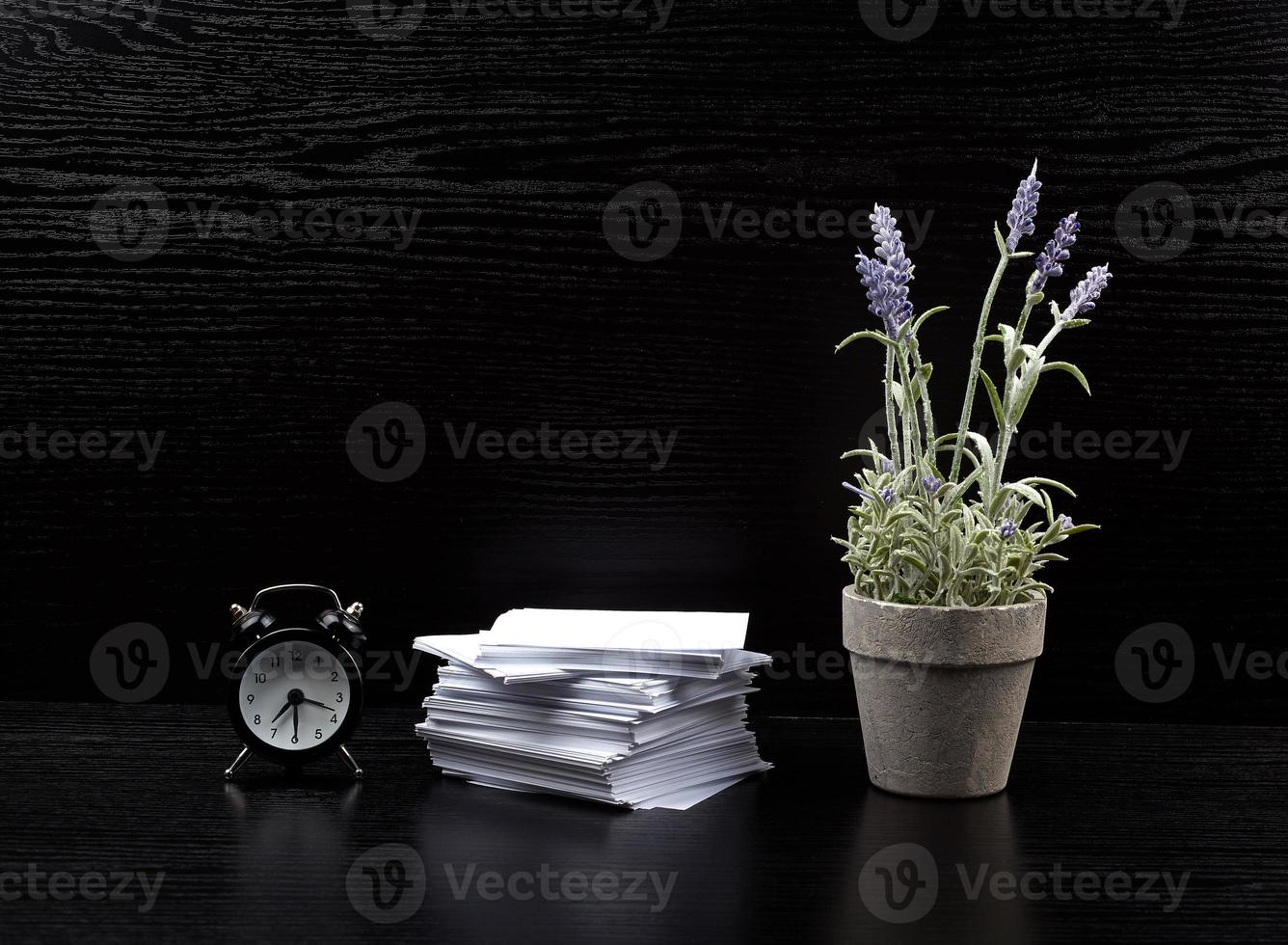 stack of white square note papers, a ceramic pot of lavender and an alarm clock photo