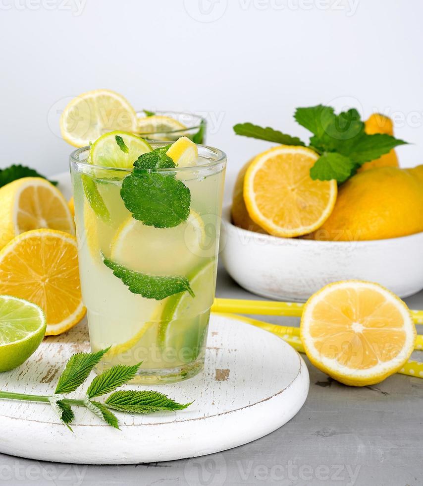 summer refreshing drink lemonade with lemons, mint leaves, lime in a glass photo