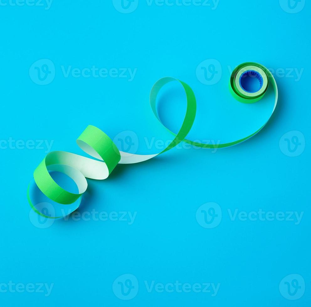 untwisted reel with green sticky stickers on a blue background photo