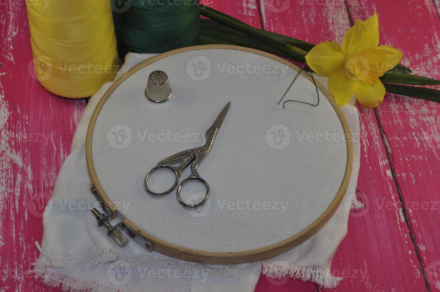 Objects for embroidery on a background of the old wooden vintage pink table photo