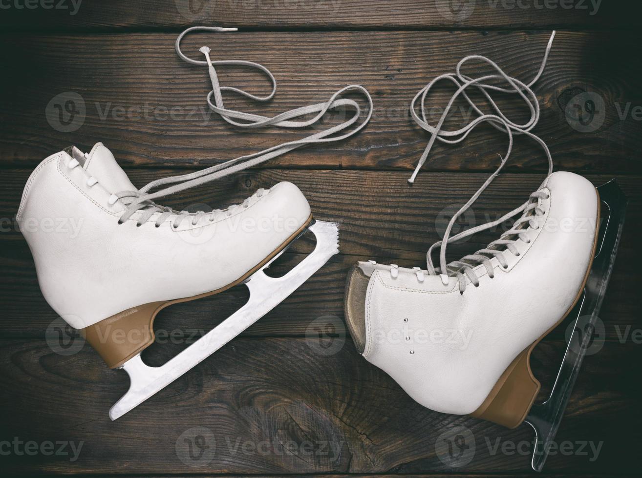 viejos patines blancos femeninos para patinaje artístico con cordones sueltos foto