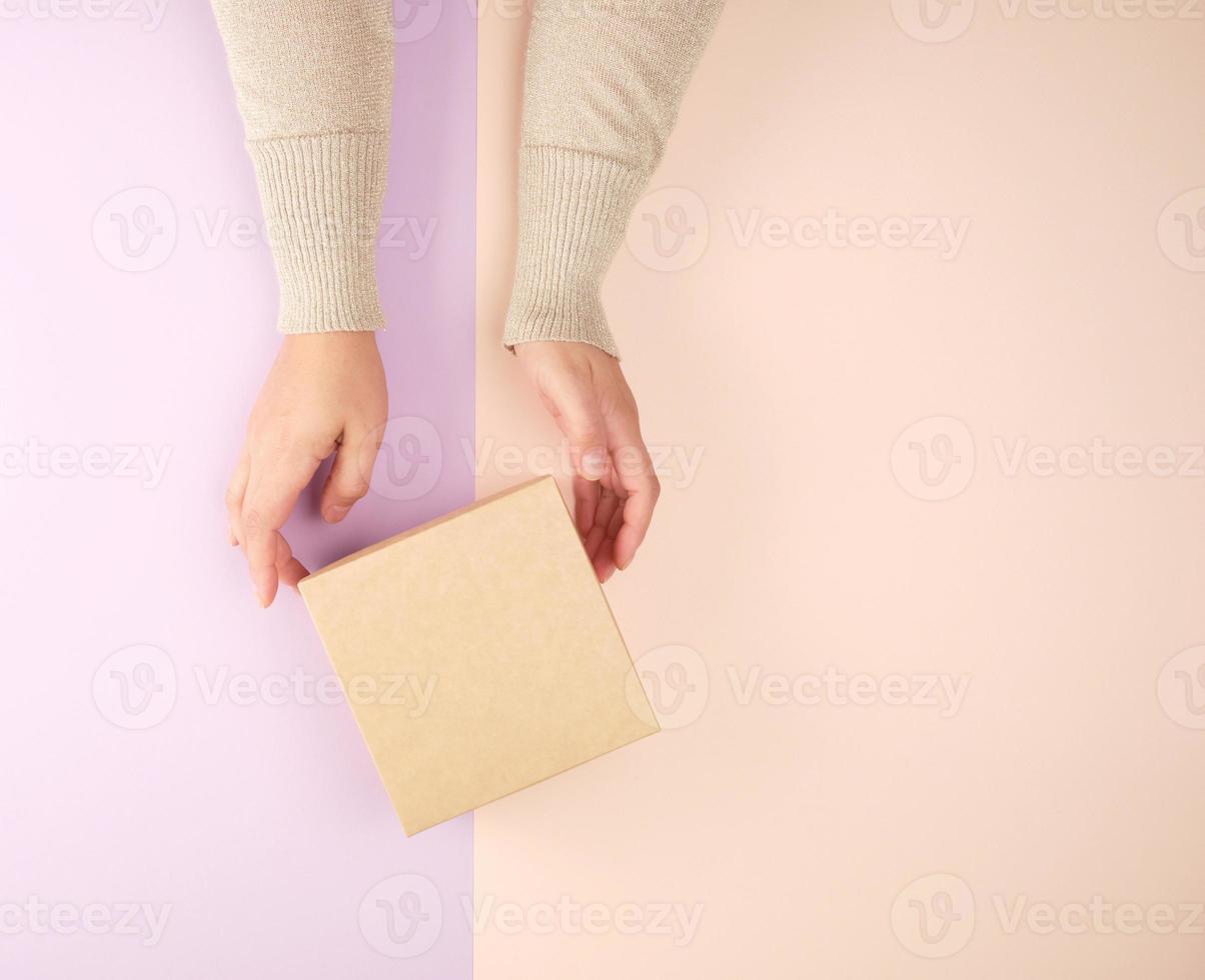 girl hold a brown square box on a purple beige background photo