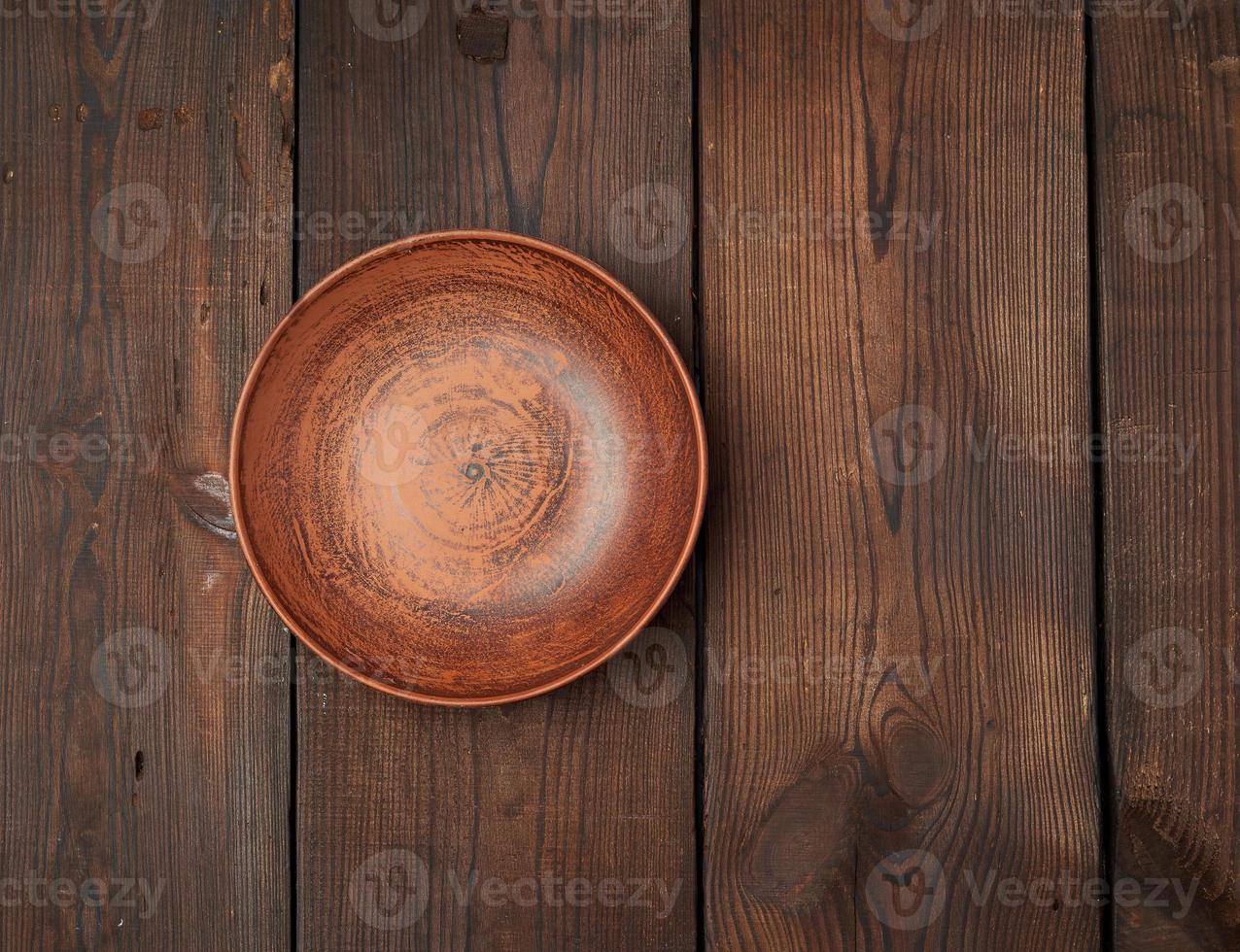 empty brown ceramic plates on a wooden table photo