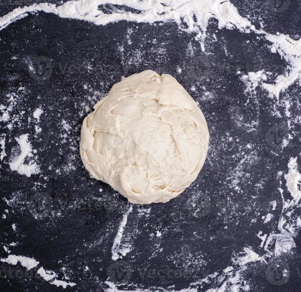 ball of wheat yeast dough on a black surface photo