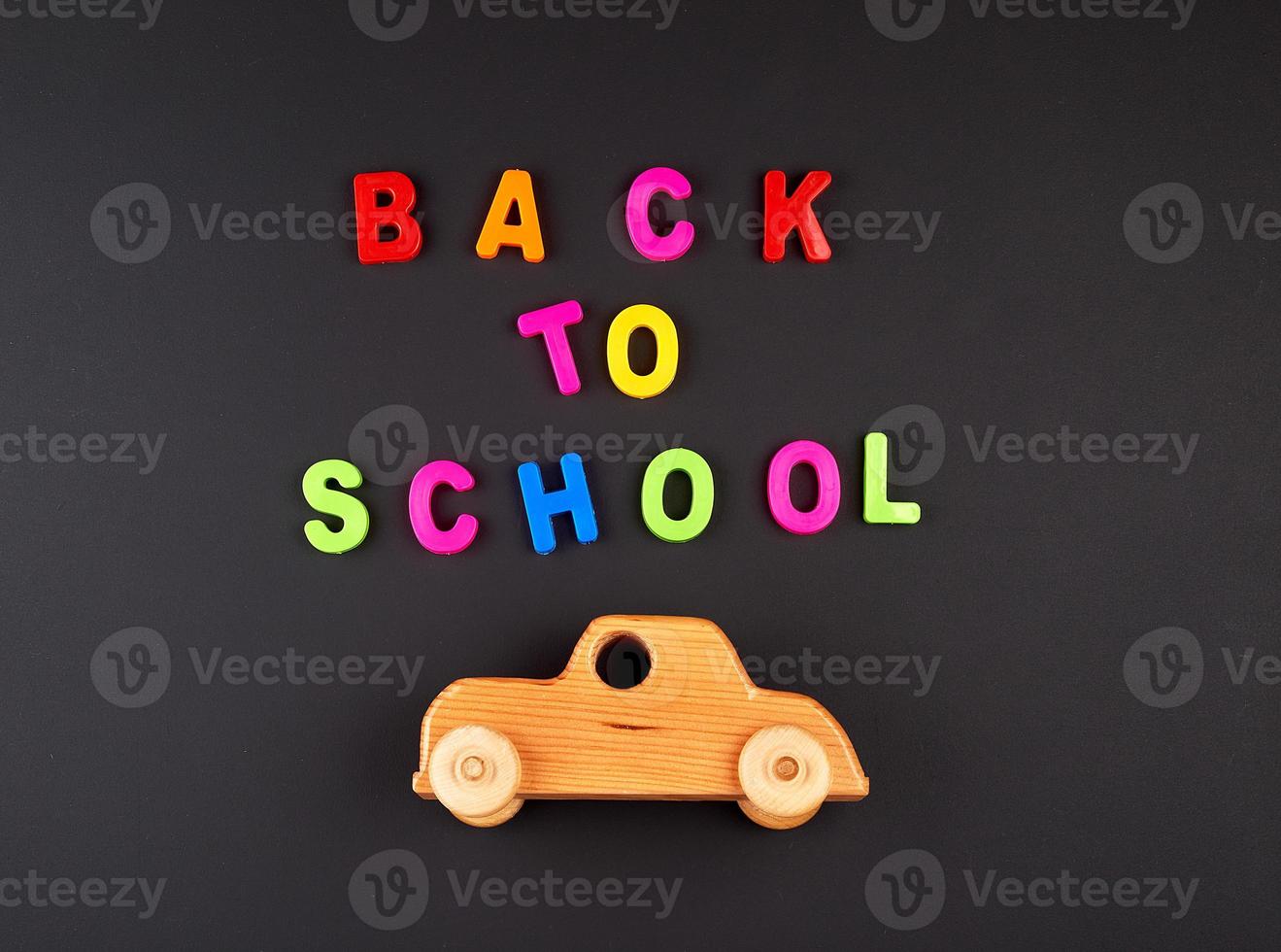 wooden baby car on black chalk board, concept back to school photo