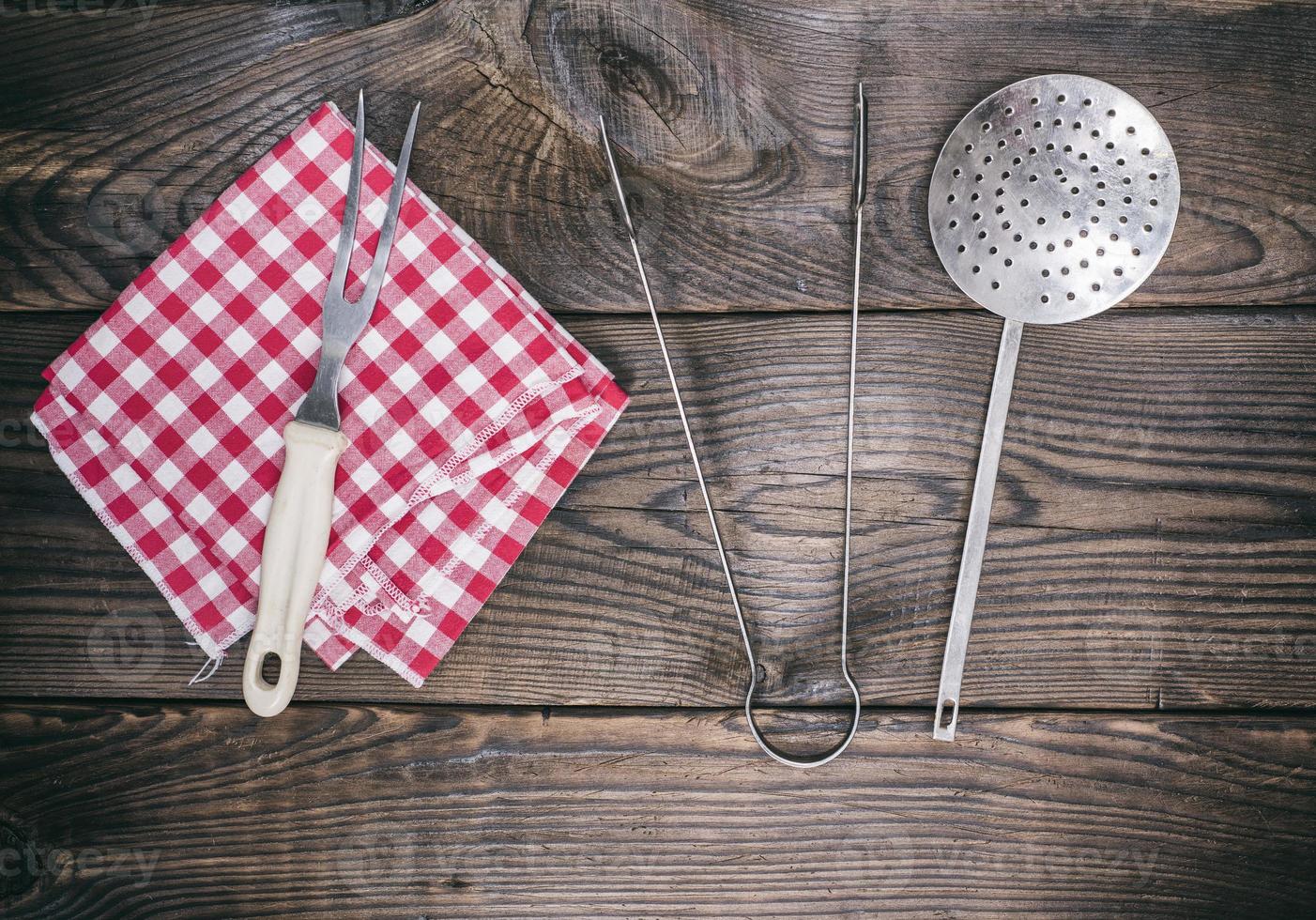 utensilios de cocina antiguos y una servilleta roja foto