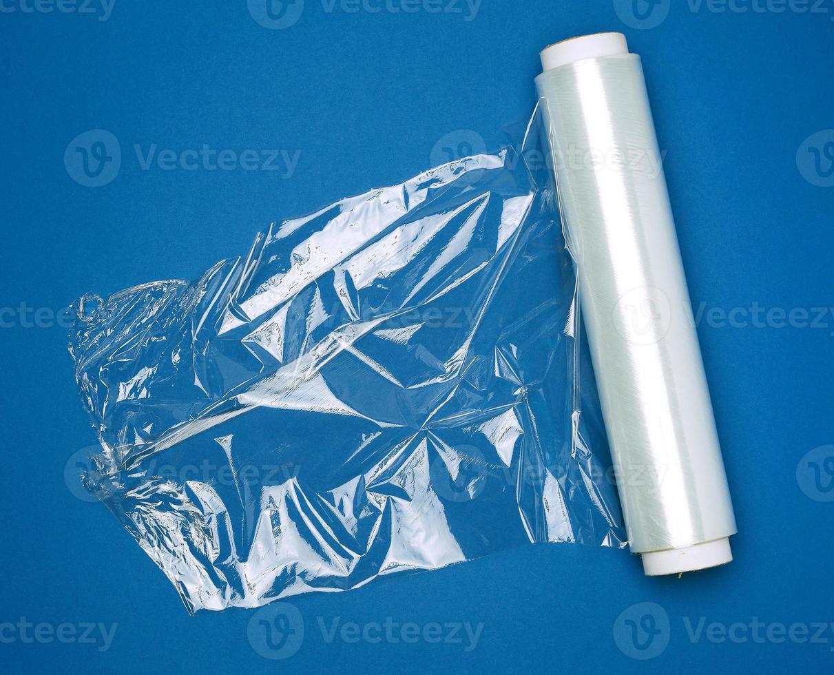 big roll of wound white transparent film for wrapping food, dark blue background photo