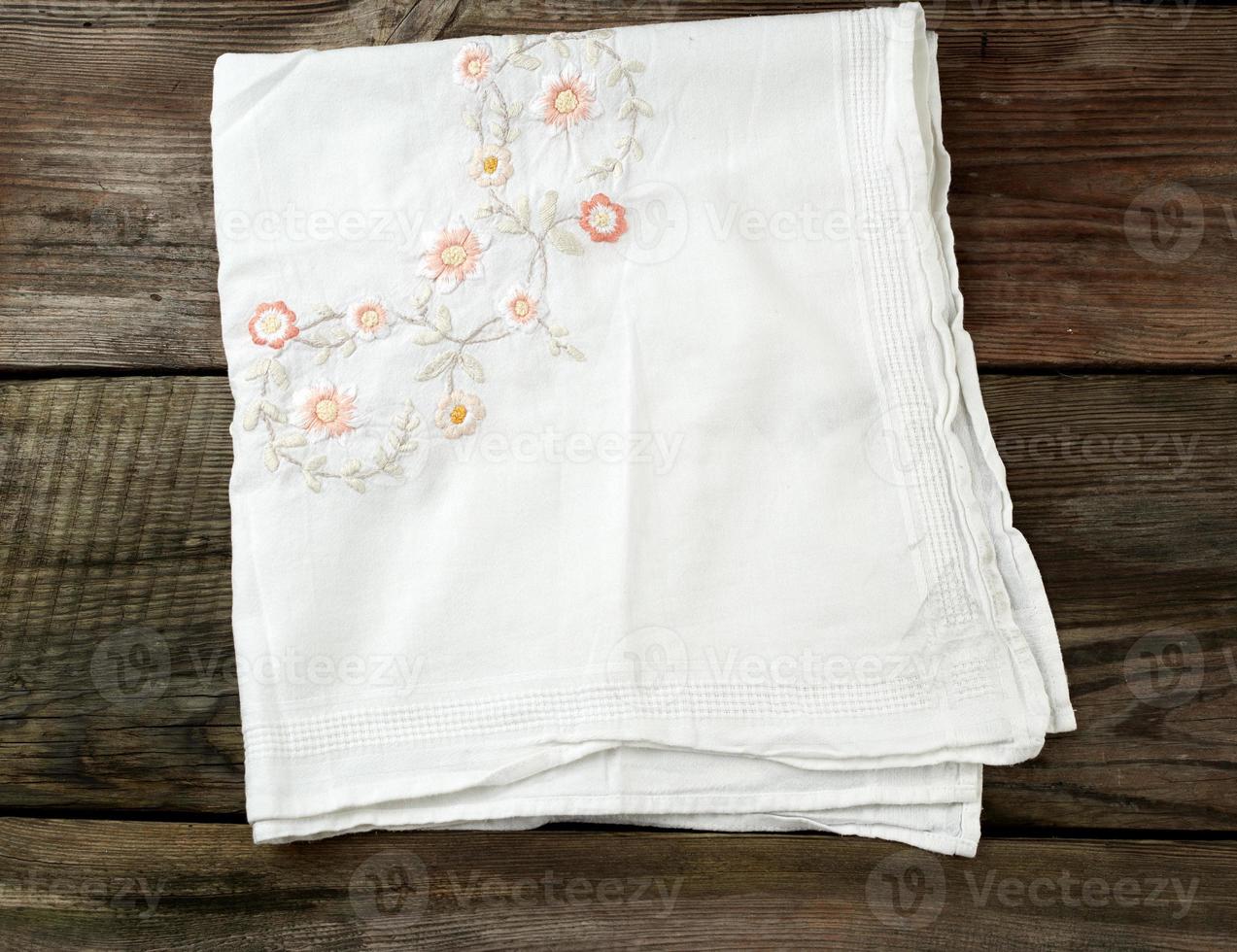 white kitchen textile towel folded on a gray wooden table from old boards, top view, empty space photo