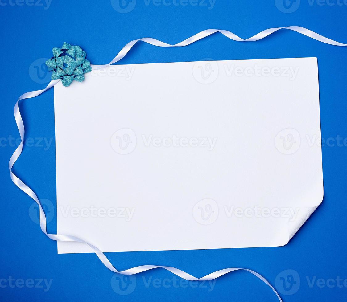 blank white sheet of paper with a curled corner and white ribbon photo