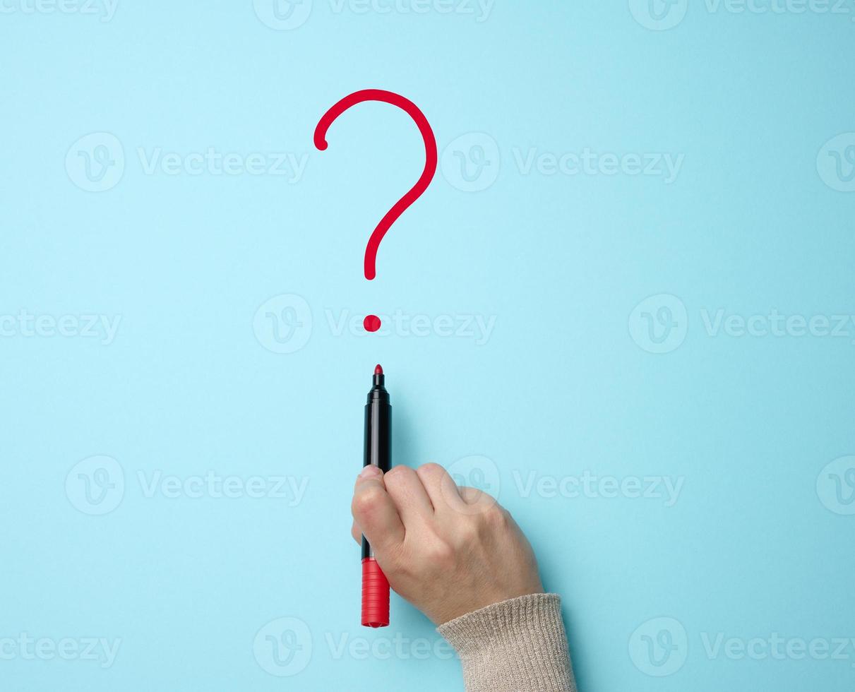 Hand drawn question mark with a red marker on a blue background. Search for an answer, find the truth photo