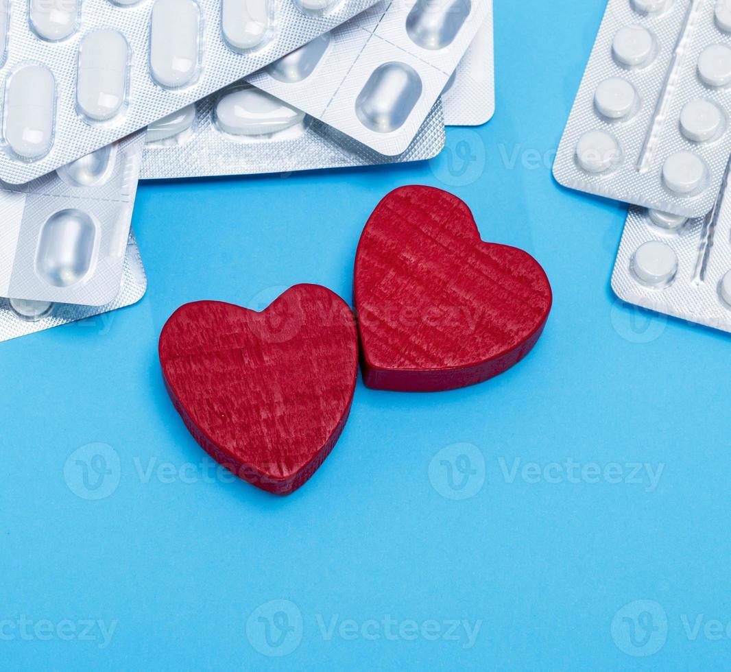 different pills in a package and two red hearts photo