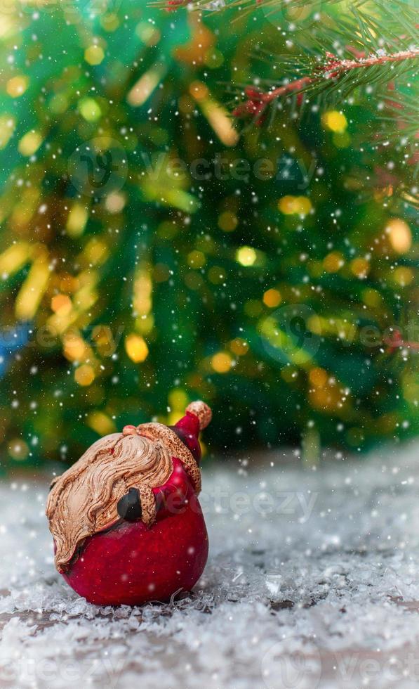 Ceramic Santa Claus on a small snow-covered wood surface photo