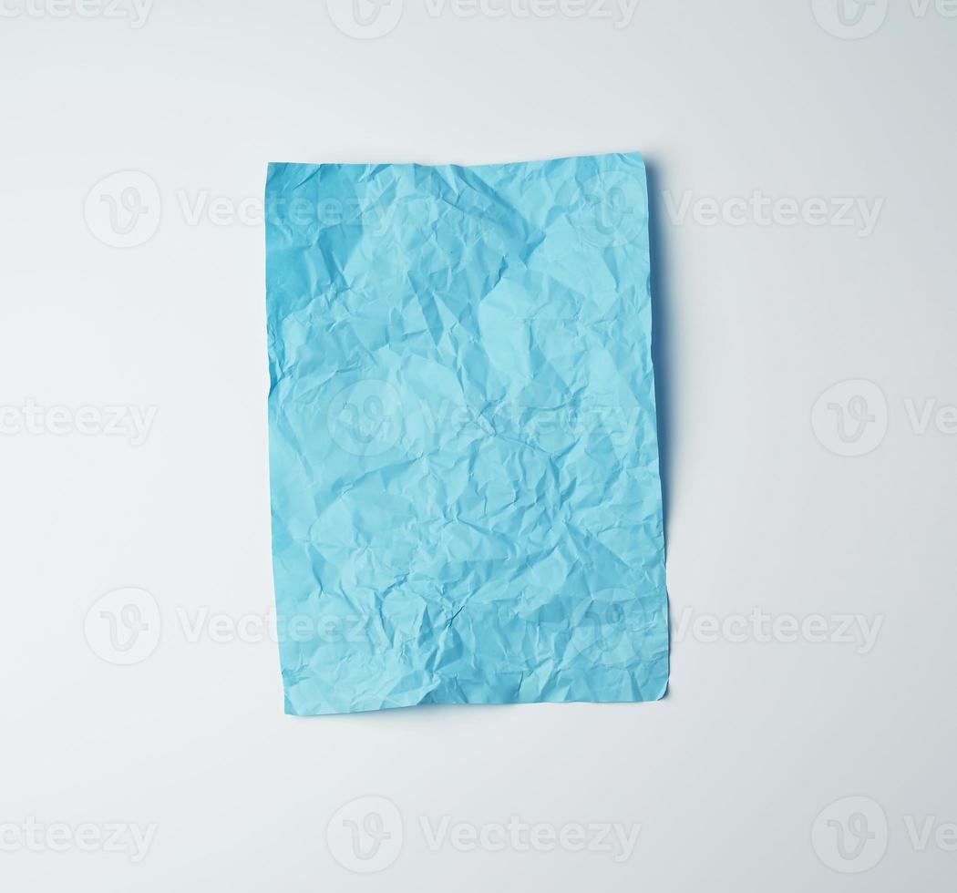 empty crumpled blue rectangular sheet of paper on a white background photo