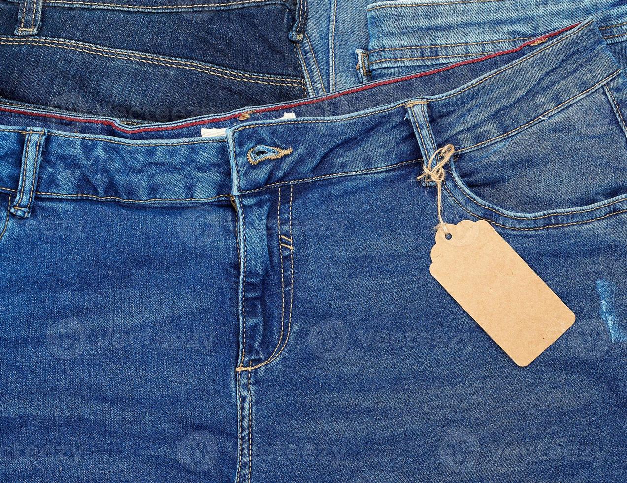 tied on a rope is an empty rectangular brown paper tag on blue jeans photo