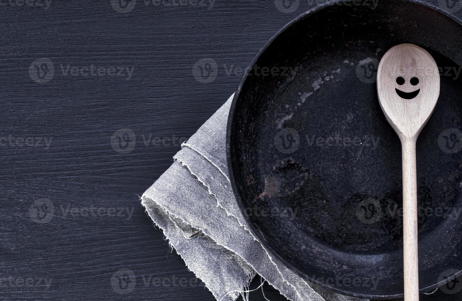 Frying pan with wooden spatula photo