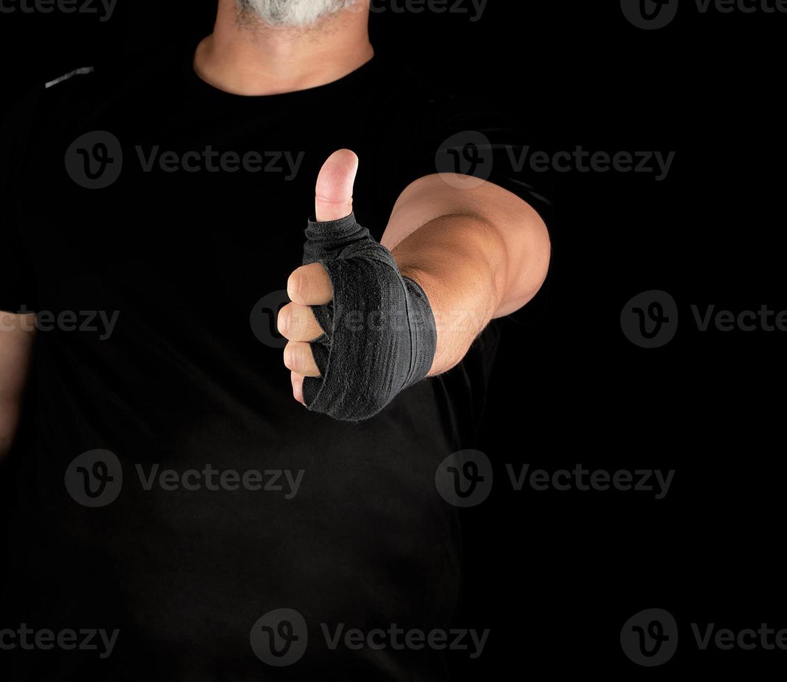 sportsman's hands wrapped in black elastic sports bandage show a like sign photo