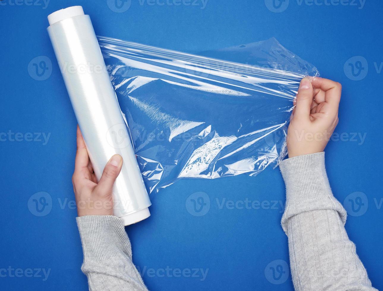 hand hold a large roll of wound white transparent film for wrapping food photo