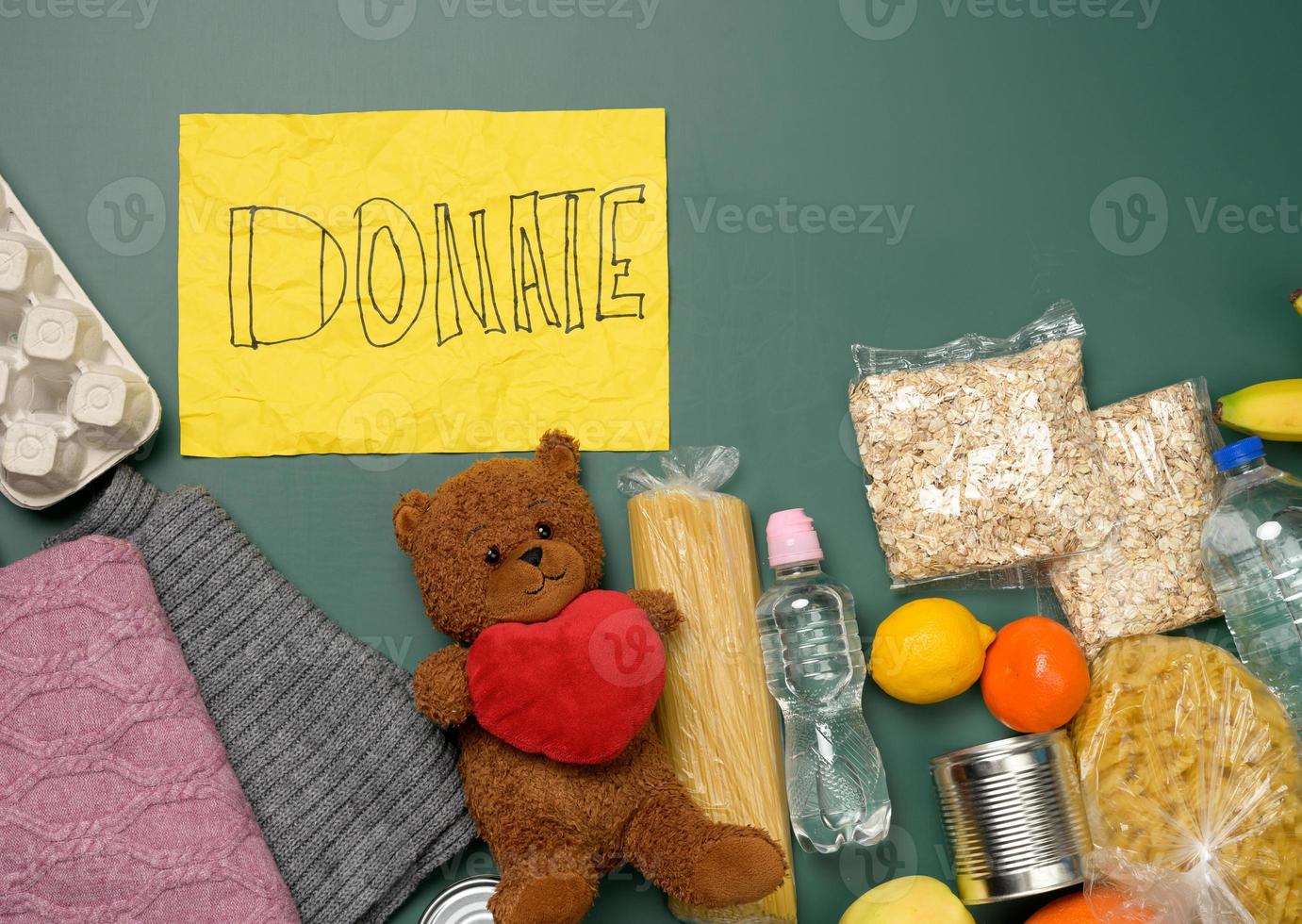 clothes and brown teddy bear on a green background, top view photo