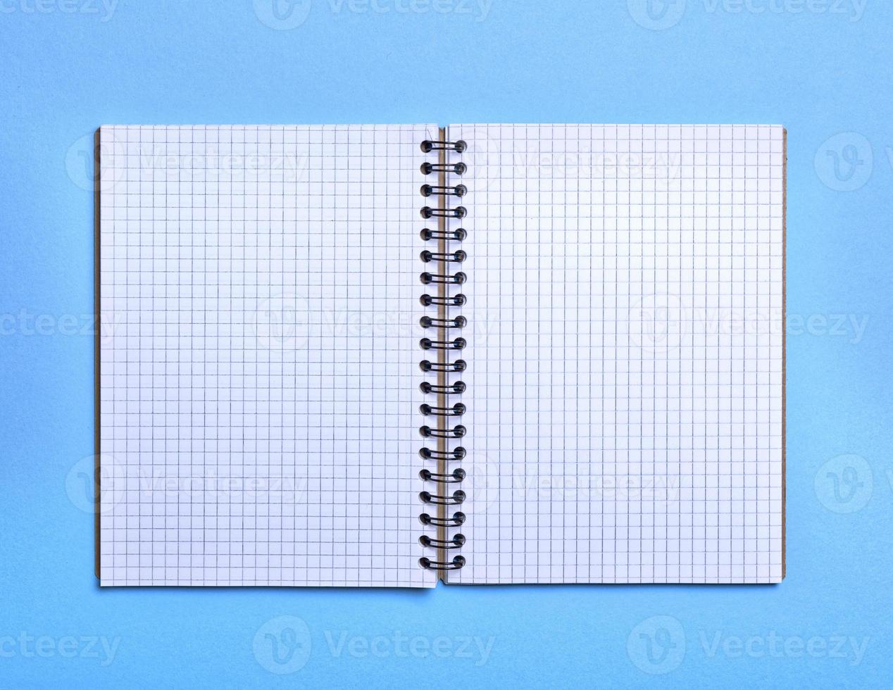 open blank notebook in a box on a blue background photo