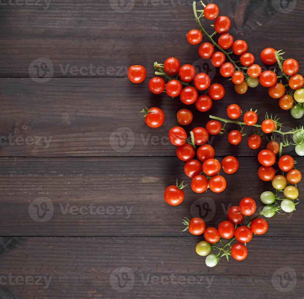 ripe red cherry tomatoes on a brown wooden board photo