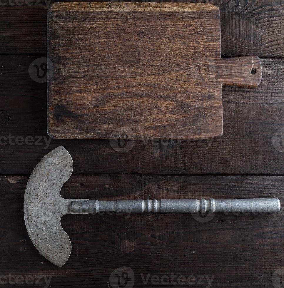 iron hatchet for cutting meat or vegetables and brown wooden cutting  board photo