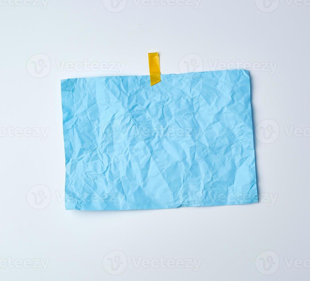 blue crumpled sheet of paper glued with adhesive tape photo