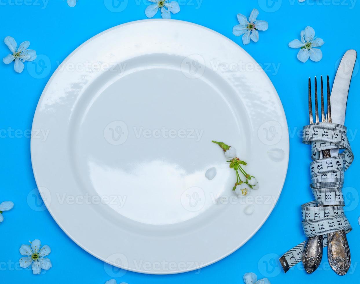 fork with a knife wrapped in a measuring tape photo