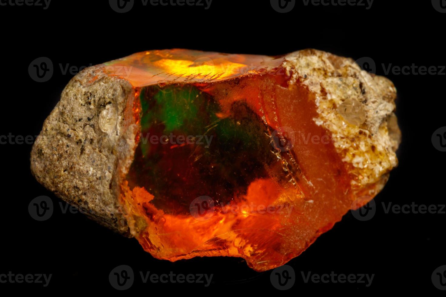 Macro Opal mineral stone in rock on black background photo