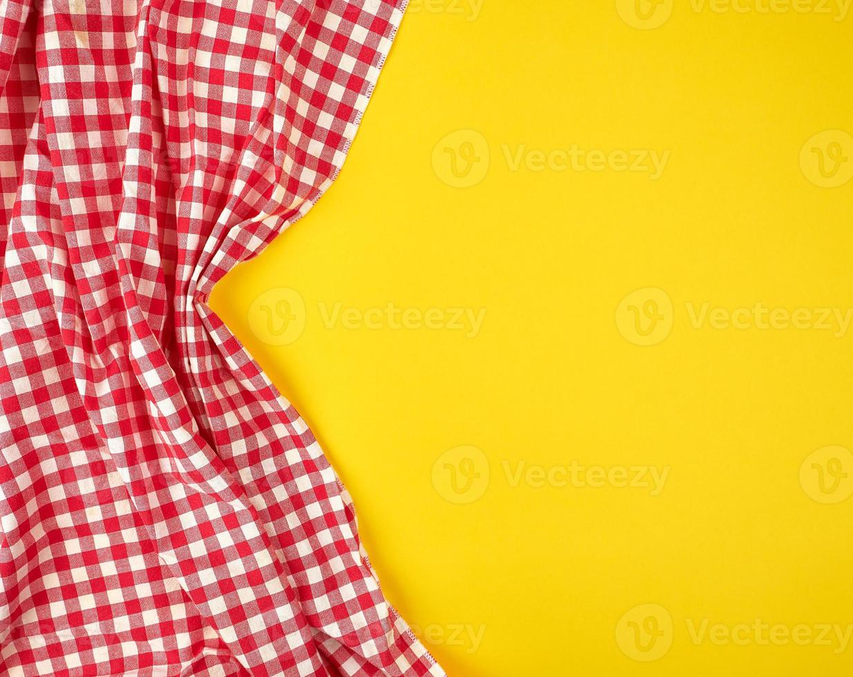 white red checkered kitchen towel on a yellow background photo